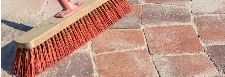 Besen reinigt Pflastersteine